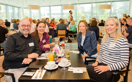 Four UCD alumni sitting at a table during their UCD Science Milestone Reunion.